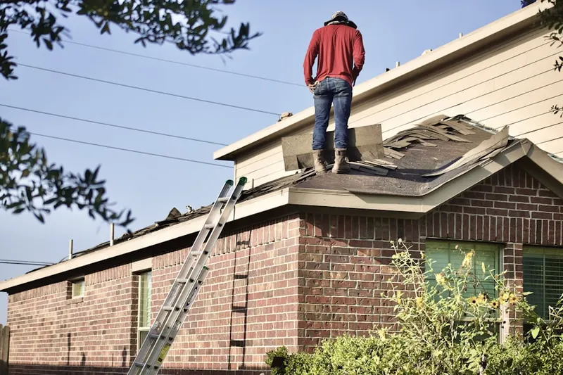 Professional roofer working on a residential roof in Almond
